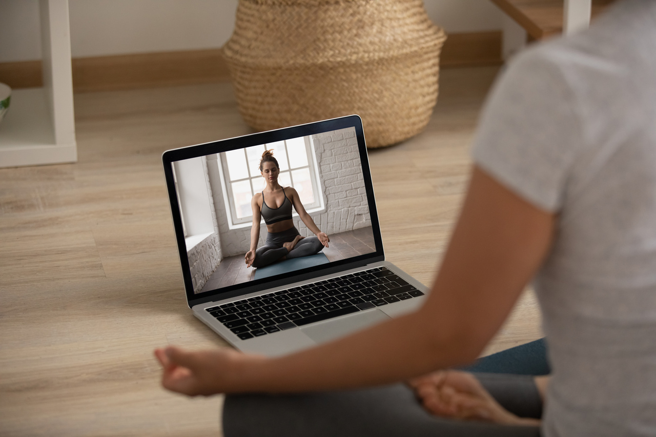 Woman practice yoga watching online class on computer